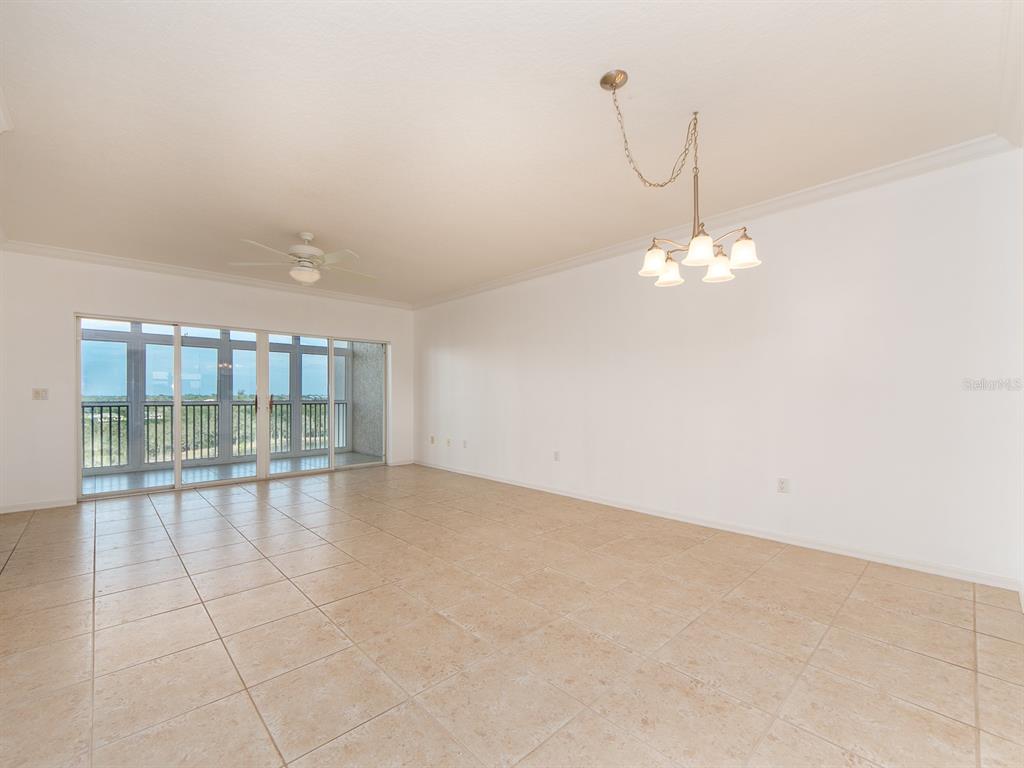 6550 Shoreline Drive, Unit 7502 St. Petersburg, FL 33708 - Photo 9 of 30 wooden floor in an empty room with chandelier