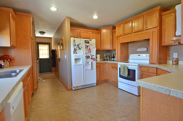 3503 East 10th Road Utica, IL 61373 - Photo 2 of 14 a kitchen with stainless steel appliances granite countertop a refrigerator a sink dishwasher and wooden cabinets with wooden floor