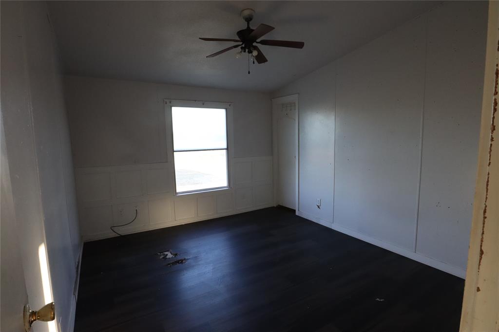1437 West Loop 254 Ranger, TX 76470 - Photo 15 of 27 wooden floor in an empty room with a window