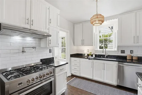 a kitchen with stainless steel appliances a stove a sink and cabinets