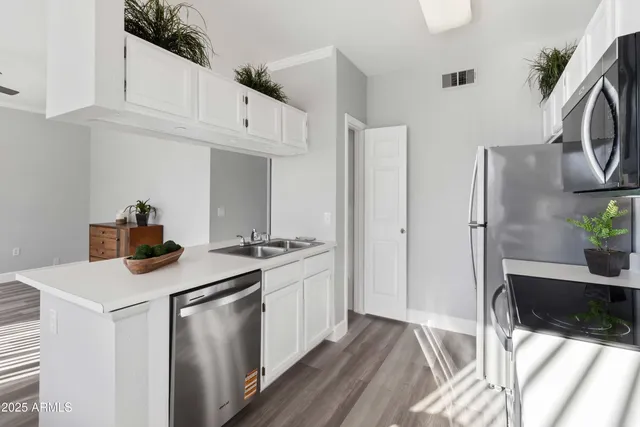 a kitchen with stainless steel appliances granite countertop a refrigerator and a stove top oven