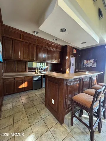 a kitchen with stainless steel appliances granite countertop a table chairs sink and cabinets