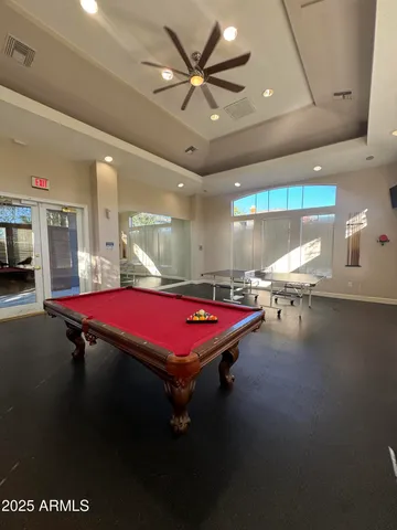a room with pool table and windows