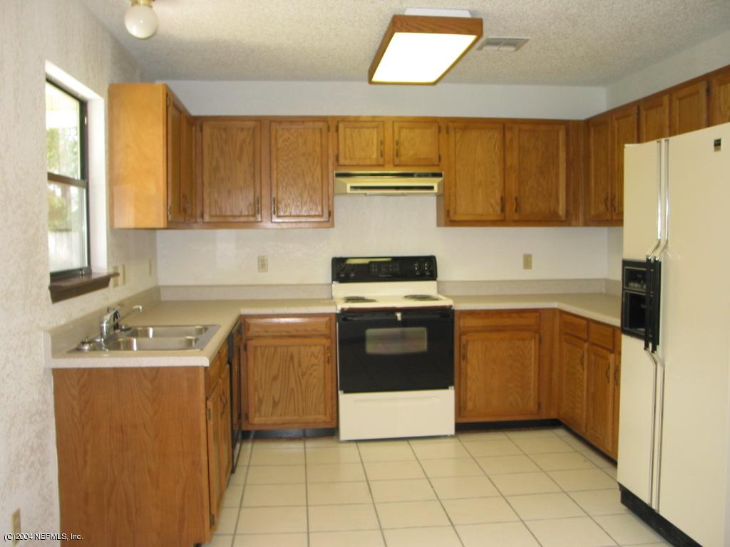 1670 Rusty Rail Road Jacksonville, FL 32225 - Photo 3 of 3 a kitchen with a stove a sink and a refrigerator