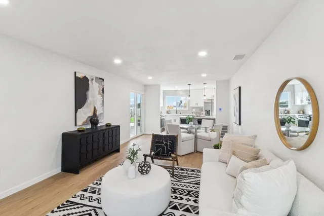 a living room with furniture a large window and a table
