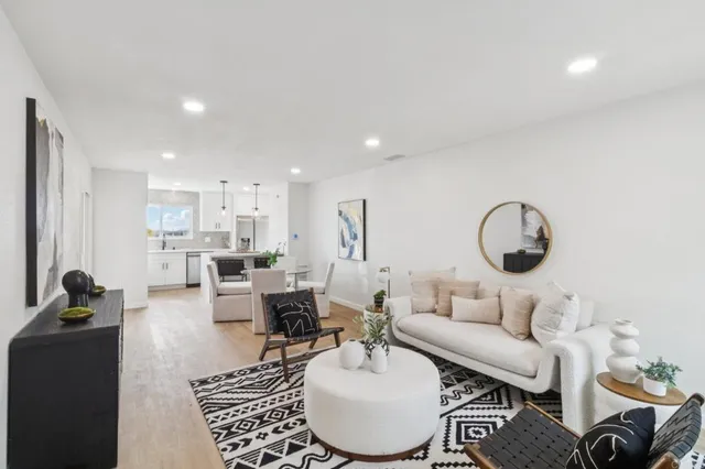 a living room with furniture a rug and white walls