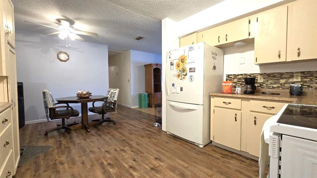 9430 Southwest 102nd Place Ocala, FL 34481 - Photo 13 of 51 a kitchen with stainless steel appliances a refrigerator a stove a dining table and chairs with wooden floor