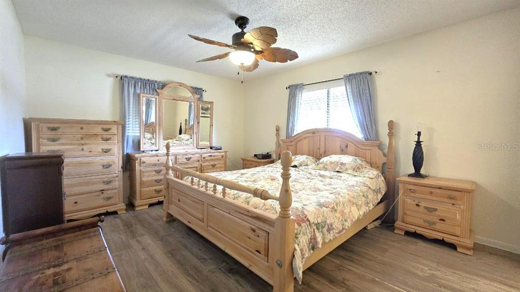 9430 Southwest 102nd Place Ocala, FL 34481 - Photo 21 of 51 a bed sitting in a bedroom next to a window and a chandelier