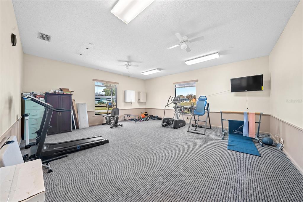 9430 Southwest 102nd Place Ocala, FL 34481 - Photo 49 of 51 a room with gym equipment and a flat screen tv