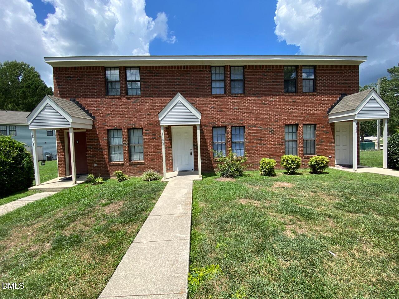 a front view of a house with yard and green space