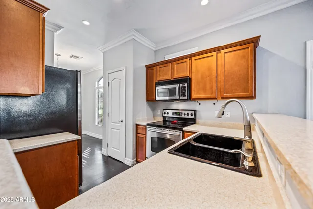 a kitchen with stainless steel appliances a stove sink and refrigerator