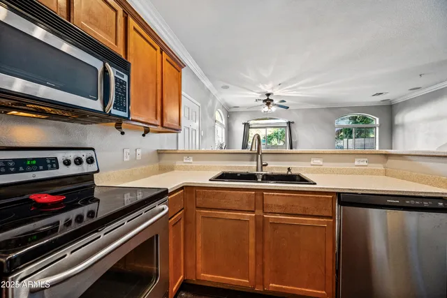 a kitchen with stainless steel appliances a stove a sink and a microwave