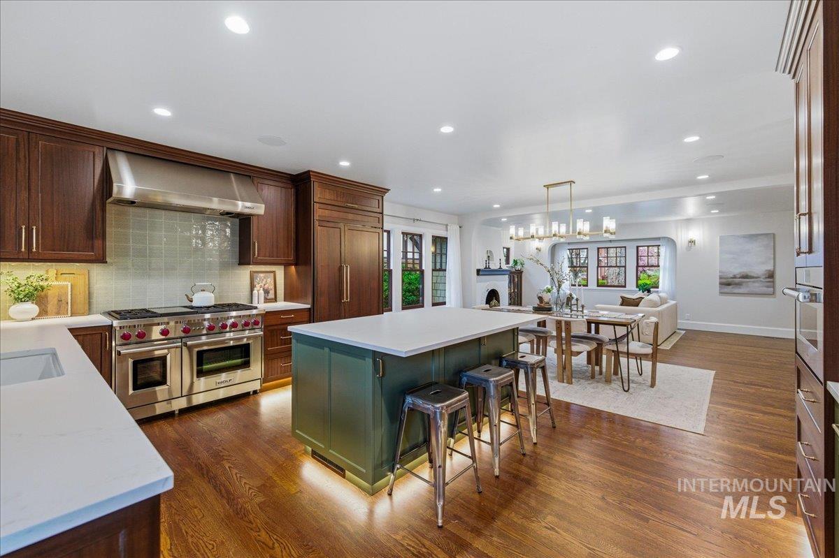 1210 North Harrison Boulevard Boise, ID 83702 - Photo 13 of 39 Kitchen with stainless steel appliances, a center island, dark wood-style floors, tasteful backsplash, and a breakfast bar area