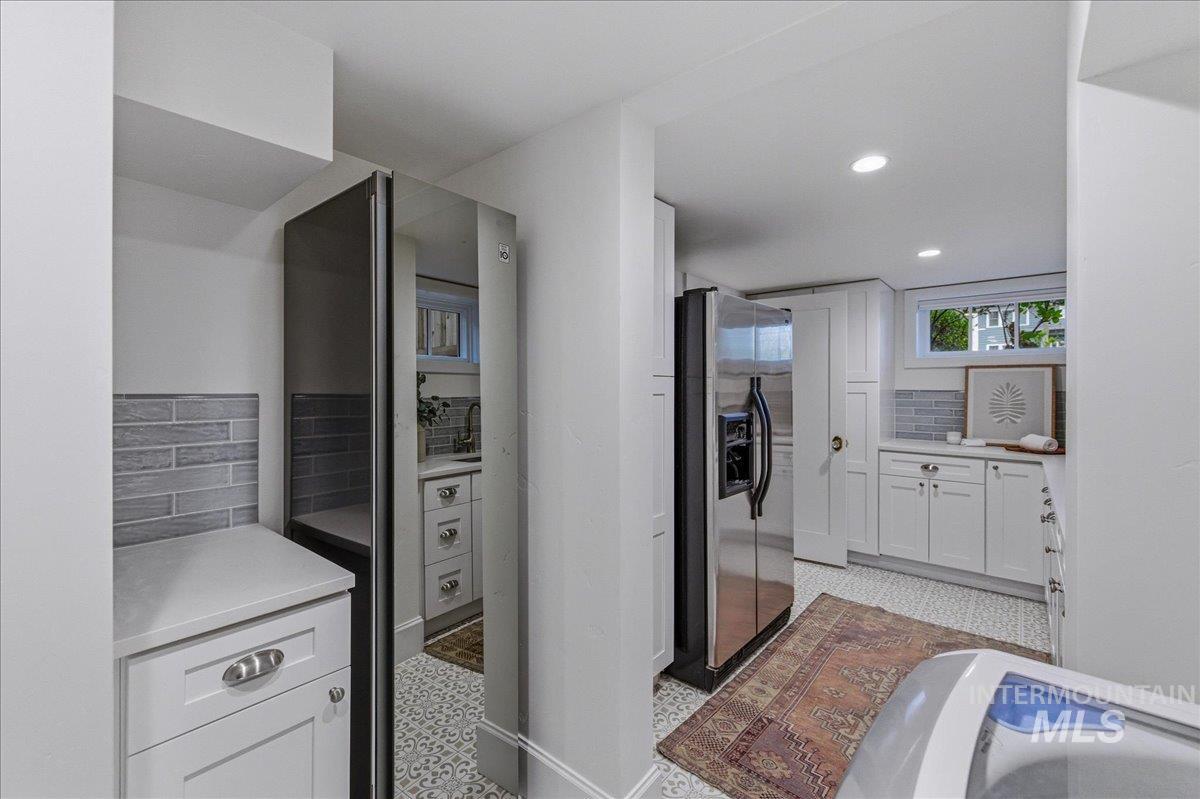 1210 North Harrison Boulevard Boise, ID 83702 - Photo 32 of 39 Kitchen with stainless steel refrigerator with ice dispenser, white cabinets, light floors, recessed lighting, and decorative backsplash