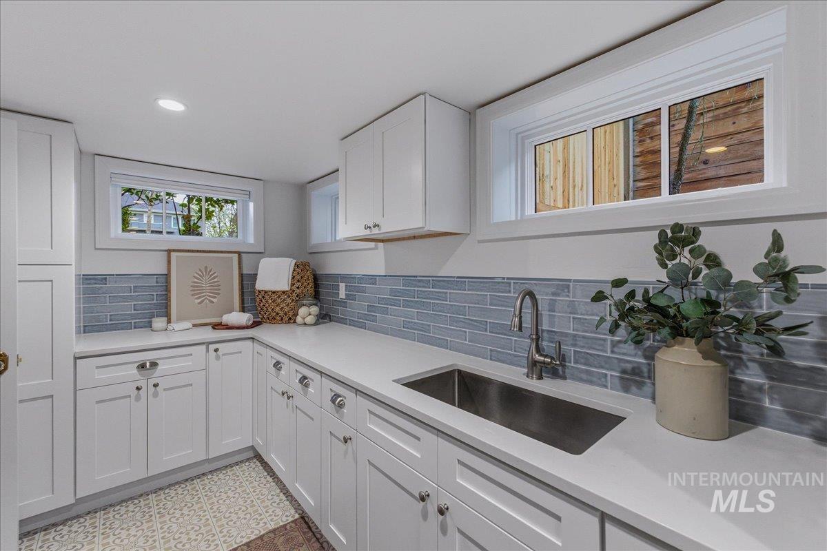 1210 North Harrison Boulevard Boise, ID 83702 - Photo 33 of 39 Kitchen with white cabinets, decorative backsplash, light stone countertops, light floors, and recessed lighting
