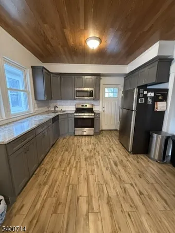 a kitchen with granite countertop a refrigerator and a sink