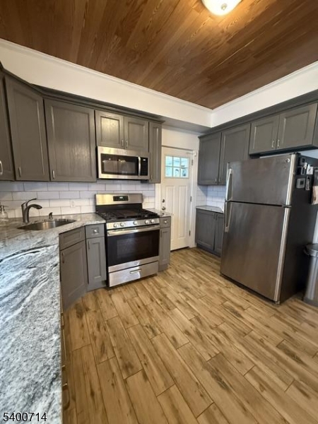 42 North Willow Street, Unit 2 Montclair, NJ 07042 - Photo 5 of 13 a kitchen with a refrigerator stove and wooden cabinets