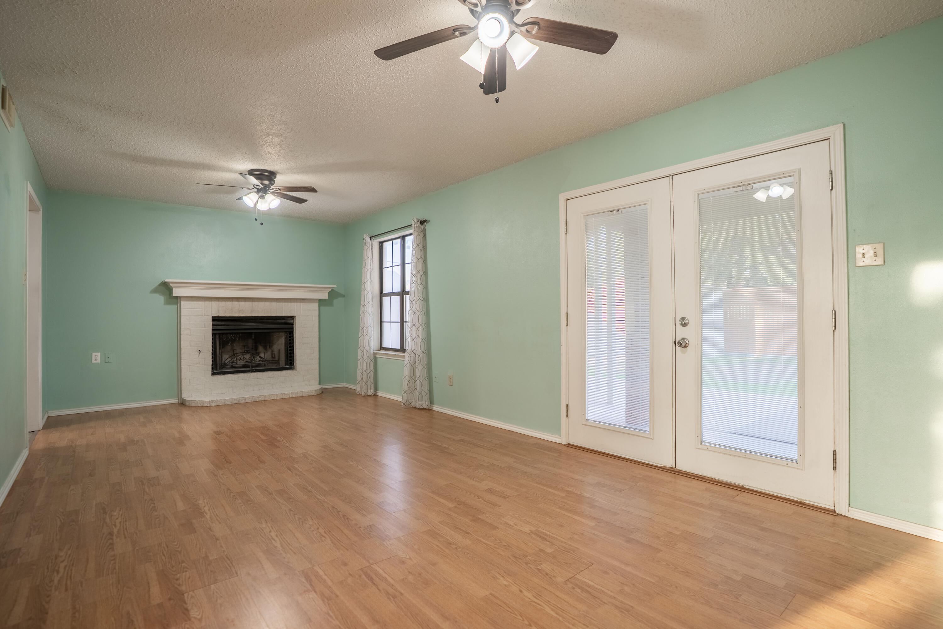 512 North Grover Avenue Lubbock, TX 79416 - Photo 13 of 34 a view of an empty room with chandelier fan and fireplace