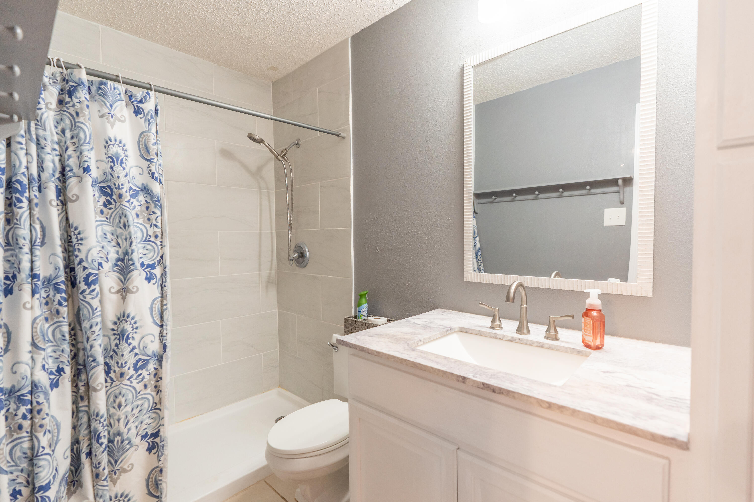 512 North Grover Avenue Lubbock, TX 79416 - Photo 19 of 34 a bathroom with a granite countertop sink toilet and shower