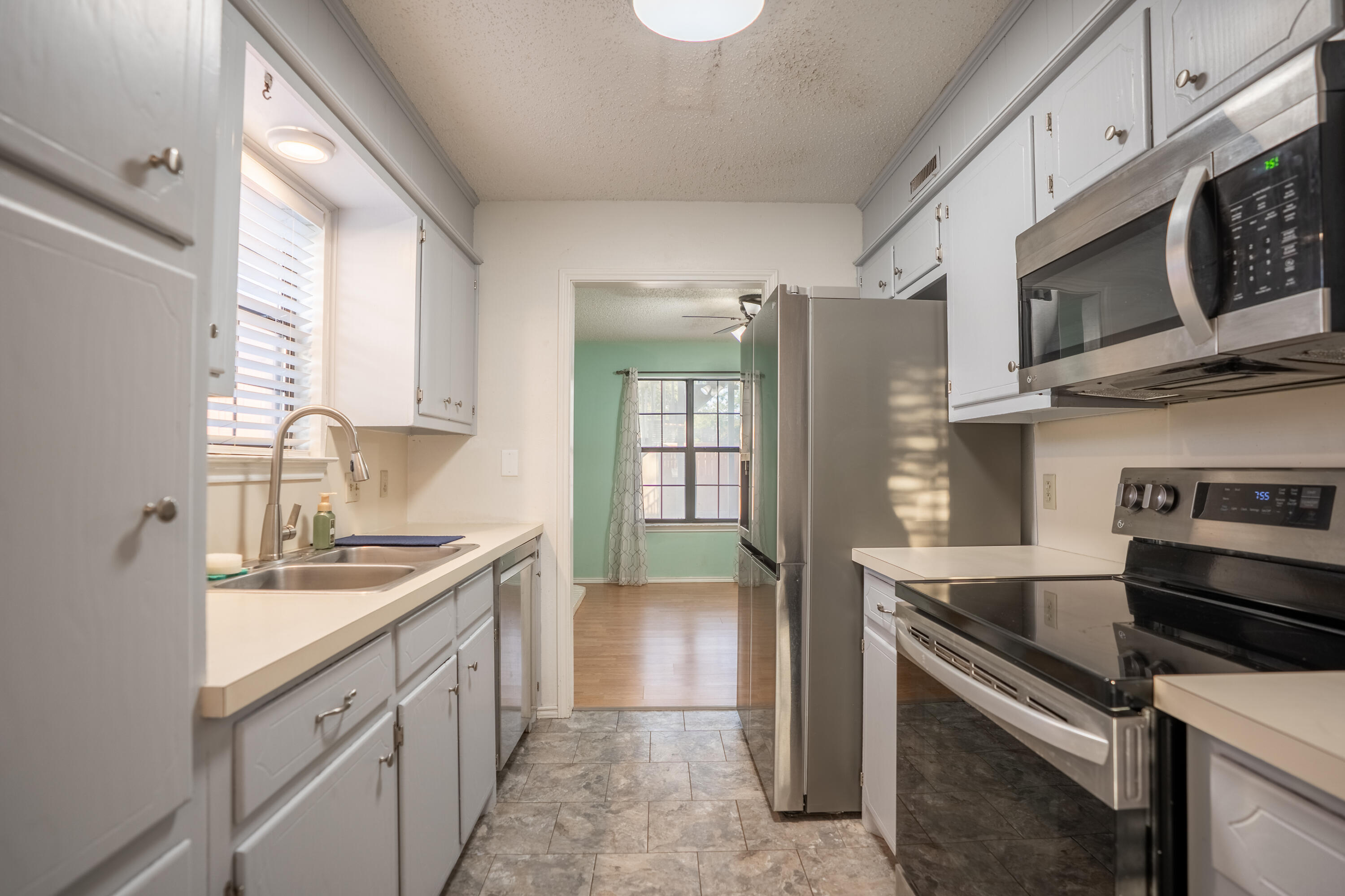 512 North Grover Avenue Lubbock, TX 79416 - Photo 7 of 34 a kitchen with stainless steel appliances granite countertop a sink and a stove