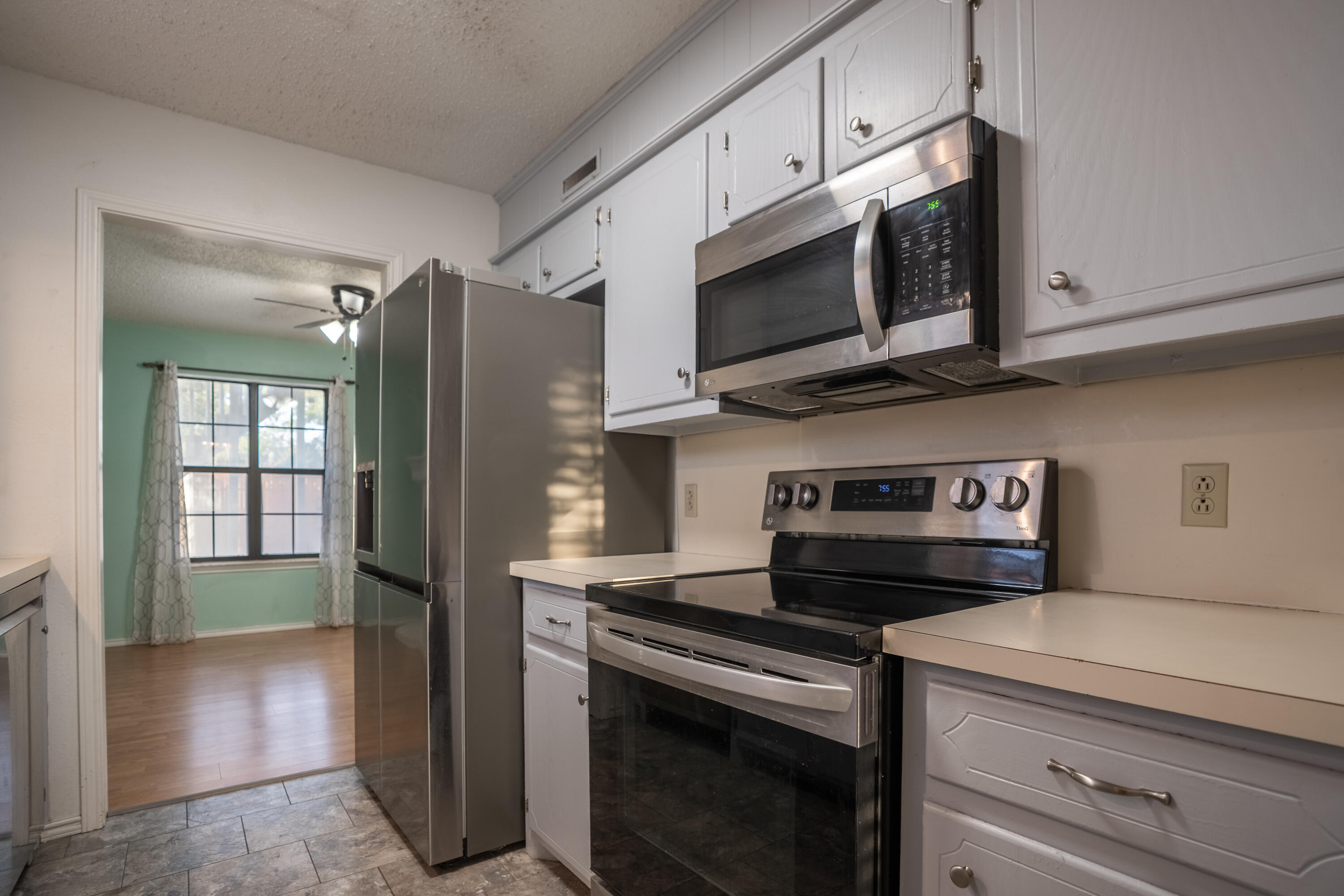 512 North Grover Avenue Lubbock, TX 79416 - Photo 9 of 34 a kitchen with stainless steel appliances a stove microwave and sink