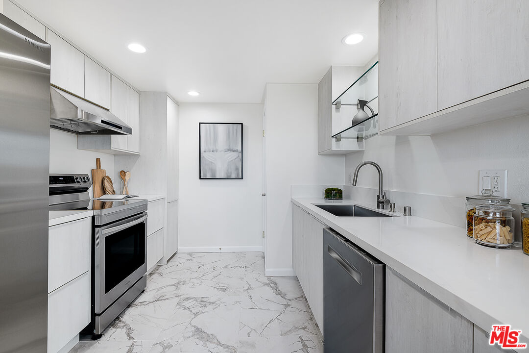 2385 Roscomare Road Los Angeles, CA 90077 - Photo 13 of 38 a kitchen with stainless steel appliances granite countertop a sink stove and cabinets