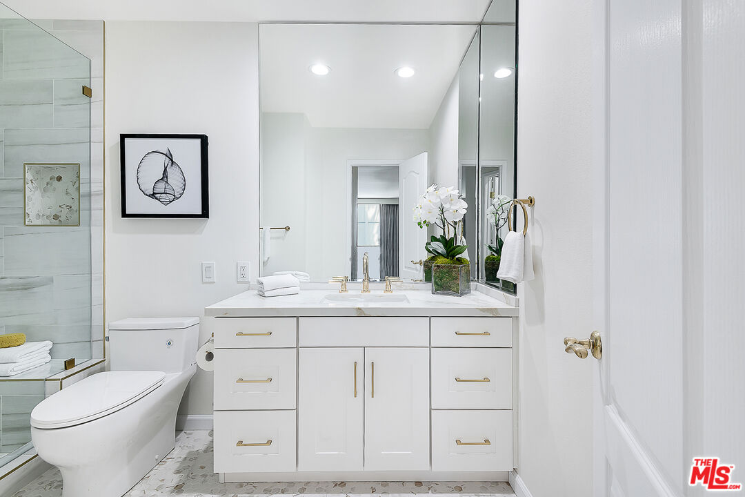 2385 Roscomare Road Los Angeles, CA 90077 - Photo 20 of 38 a bathroom with a toilet a sink a vanity and mirror
