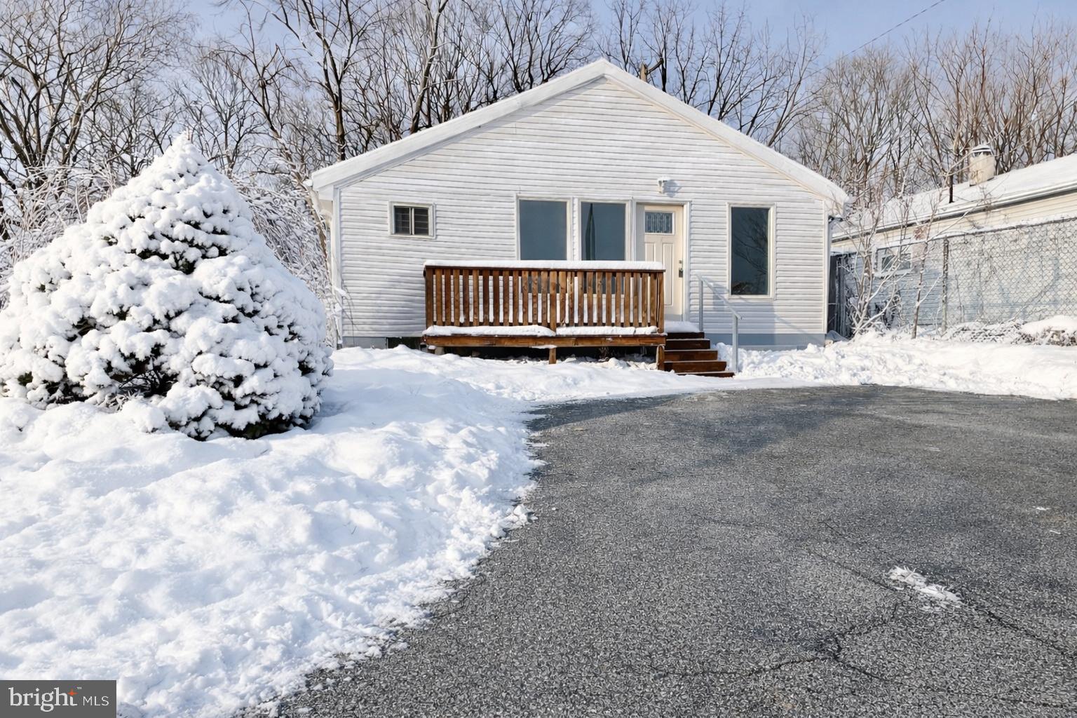 a view of a white house with a yard covered in snow