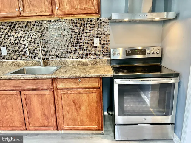 a view of kitchen with stainless steel appliances granite countertop cabinets and a wooden floor
