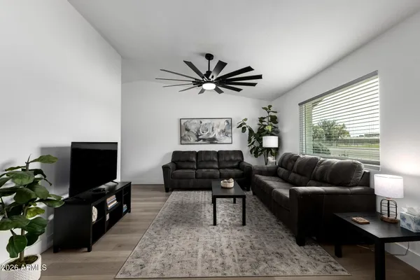 a living room with furniture and a flat screen tv with wooden floor
