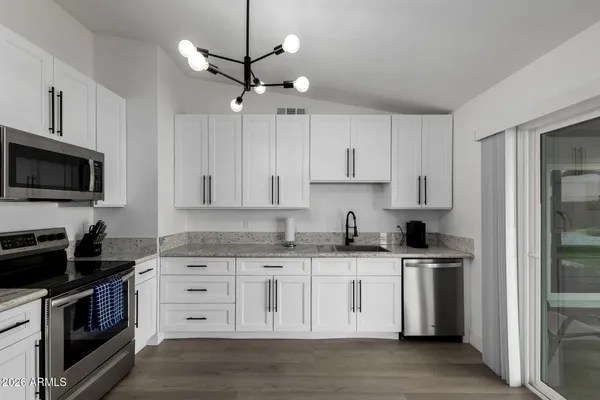 a kitchen with stainless steel appliances granite countertop a sink a stove a microwave and cabinets
