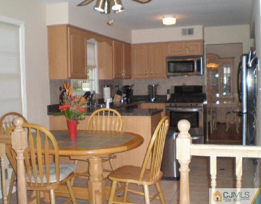 30 Brookside Road Edison, NJ 08817 - Photo 5 of 8 a kitchen with granite countertop a sink and a refrigerator