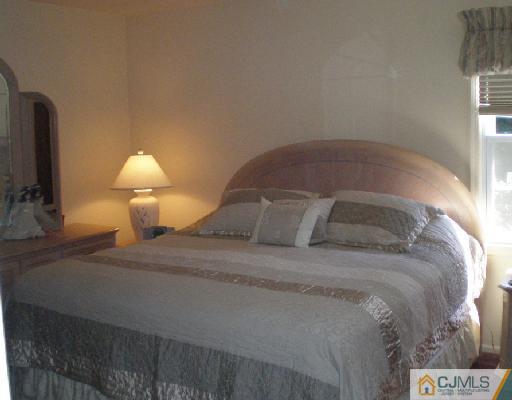 30 Brookside Road Edison, NJ 08817 - Photo 6 of 8 a bedroom with a bed and a lamp