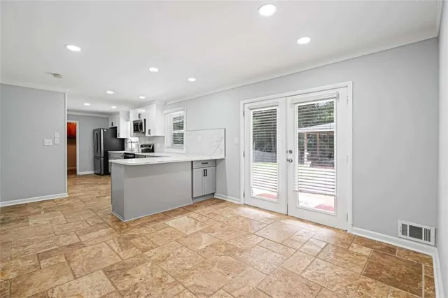 a kitchen with stainless steel appliances kitchen island granite countertop a refrigerator and cabinets