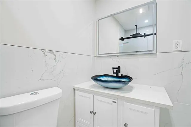 a bathroom with a sink a toilet and a mirror