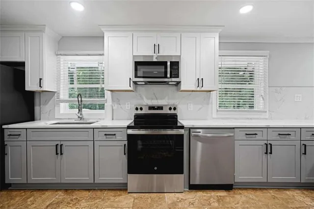 a kitchen with stainless steel appliances granite countertop a stove a sink and a microwave