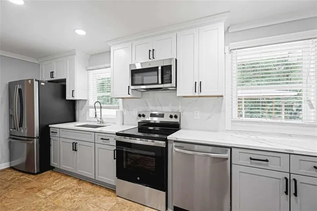 a kitchen with stainless steel appliances granite countertop a stove a refrigerator and a sink