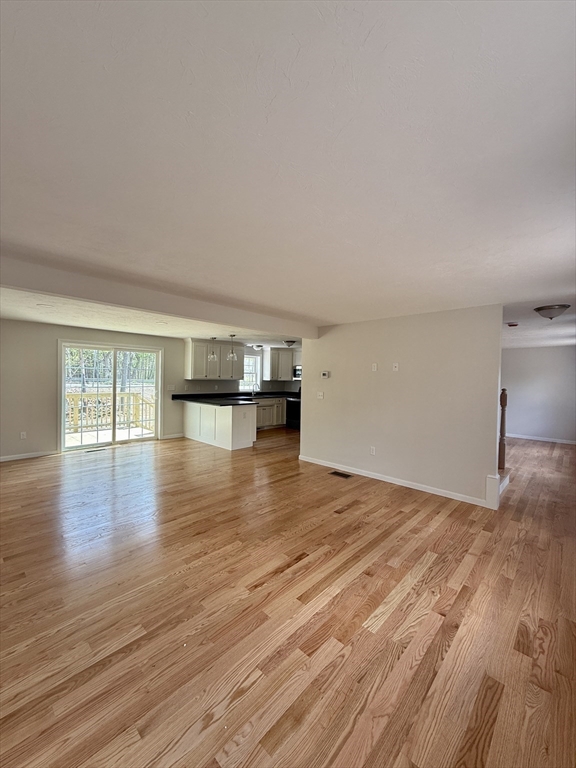 1 A Dudley Road Townsend, MA 01469 - Photo 6 of 17 a view of empty room with wooden floor and kitchen view