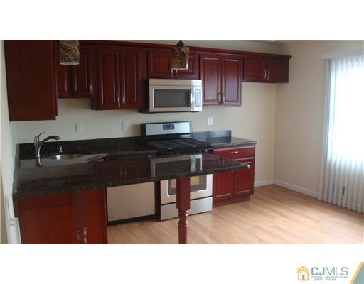 45 Princeton Road Old Bridge, NJ 08859 - Photo 7 of 10 a kitchen with a sink a microwave and cabinets