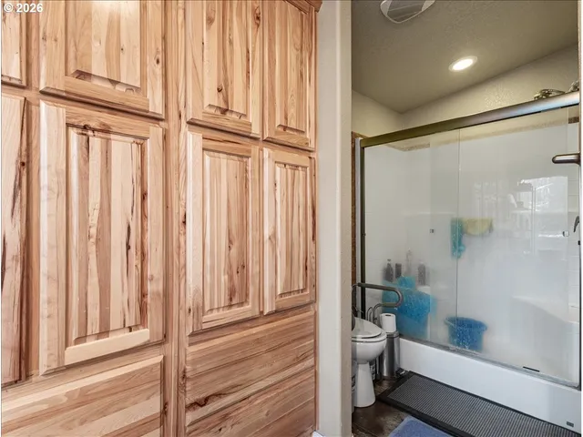 a bathroom with a granite countertop bathtub shower and toilet