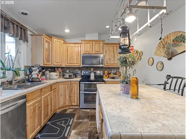 a kitchen with a sink a counter top space appliances and cabinets