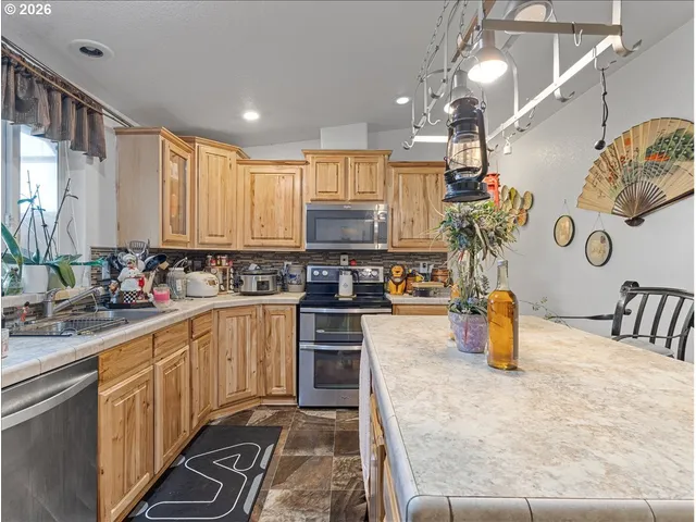 a kitchen with a sink a counter top space appliances and cabinets