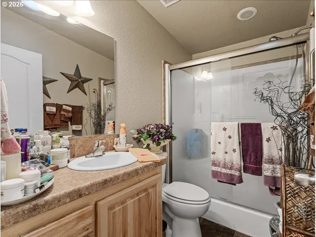 a bathroom with a granite countertop sink mirror vanity and toilet