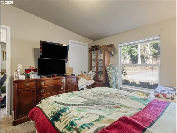 a bedroom with a bed and a flat screen tv