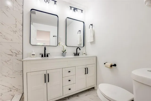 a bathroom with a toilet sink and mirror