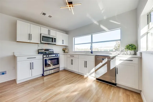 a kitchen with stainless steel appliances a white cabinets and sink