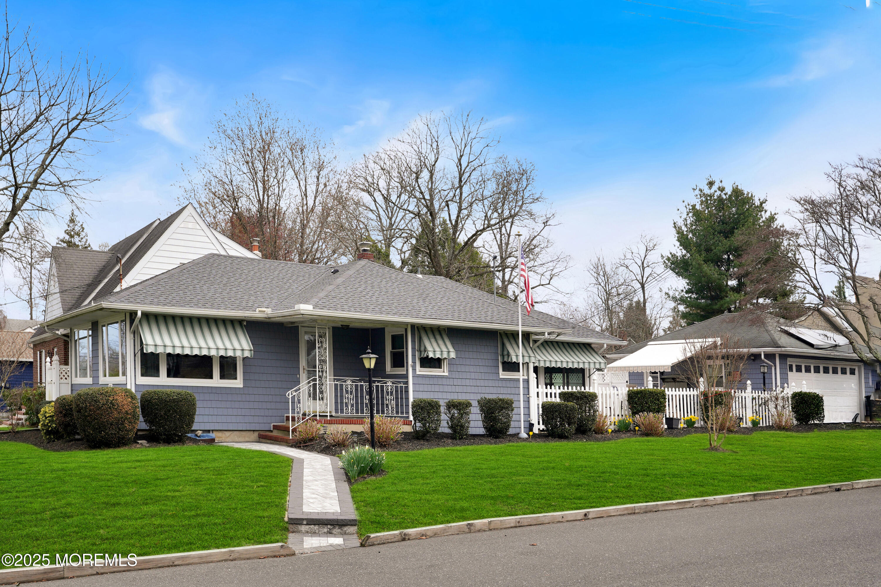 a front view of a residential houses with yard and green space