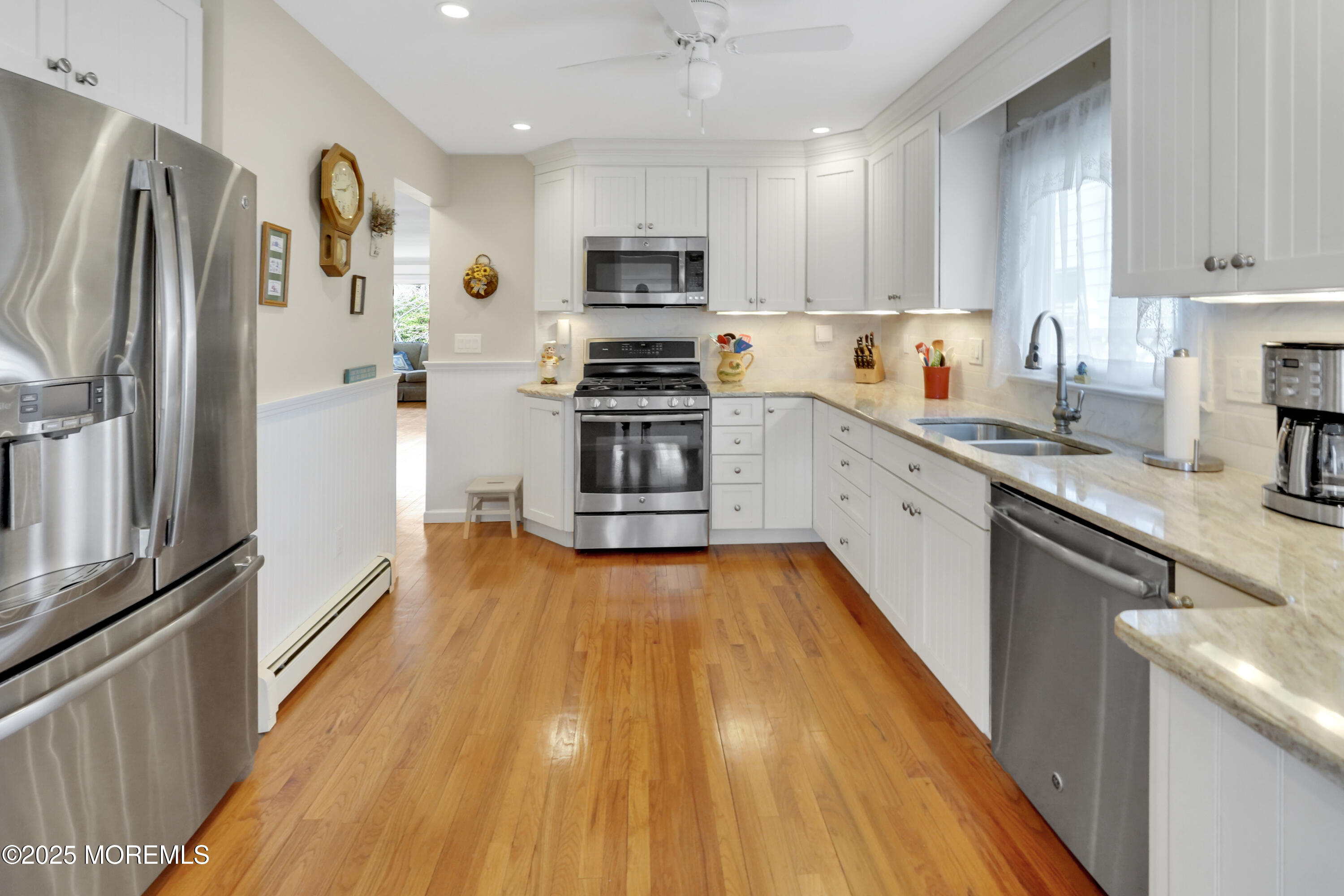 1635 Marconi Road Wall, NJ 07719 - Photo 7 of 39 a white kitchen with wooden floor and stainless steel appliances
