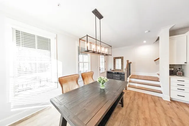 a kitchen with a table chairs refrigerator and cabinets