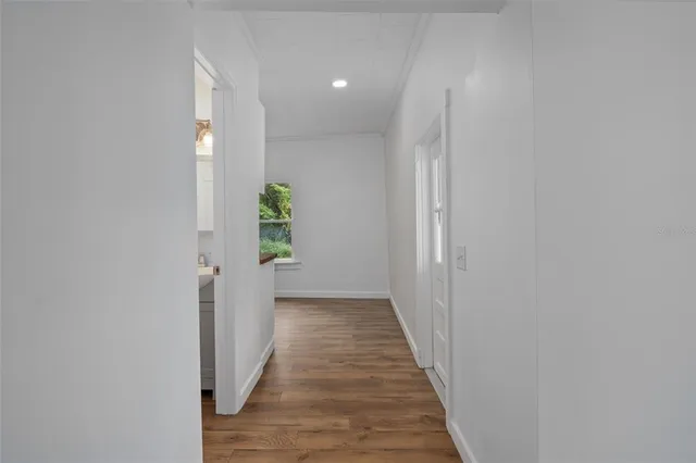 a view of a hallway with wooden floor and entryway